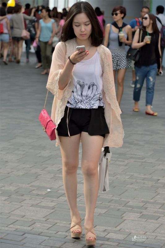 街拍夏日短发热裤美女玩手机